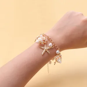 Bohemian gold chain bracelet with natural spiral seashell, starfish and white pearls