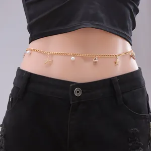Detail of golden bohemian waist chain with seashells, starfish, and pearls on black fabric