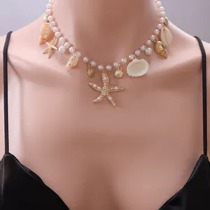Detail of bohemian necklace with gold starfish, shells and white pearls on a model