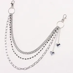 Detail of silver multi-layer metal trousers chain with black and white pixel hearts