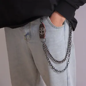 Detail of punk style double-layer metal wallet chain with leather cross charm on jeans