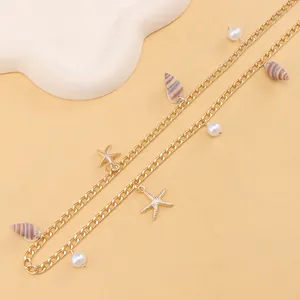 Detail of golden waist chain with imitation pearls, starfish charms and natural seashells