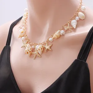 Detail of bohemian gold chain necklace with sea shells, starfish charms and pearls