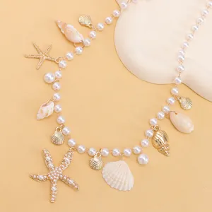 Detail view of summer beach necklace with golden starfish, seashell, and white pearl charms