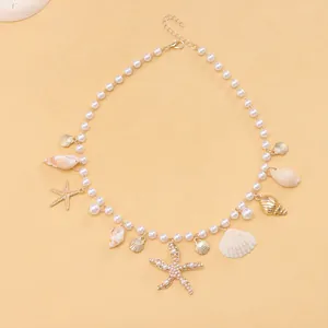 Bohemian pearl necklace with gold starfish and seashell pendants on orange background