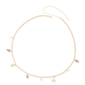 Detail of bohemian gold waist chain with sea shells, starfishes and pearls on white