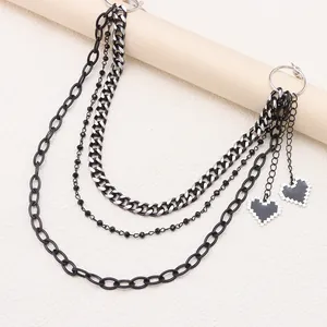 Detail of multi-layer punk pants chain with 8-bit pixel heart pendants in black and silver