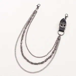 Close-up of layered punk metal pant chains with leather cross emblem and snap hooks