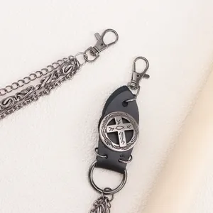 Macro view of punk metal pants chain showing leather patch and cross emblem details