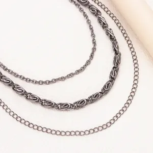 Close-up of triple-layered punk metal chains in retro silver finish and geometric design