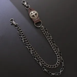 Detail of vintage metal trouser chain with leather cross badge and double layered link chains