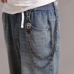 Detail of double-layer metal wallet chain with vintage cross leather patch on jeans