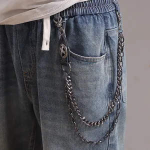Detailed view of dual-layered silver metal pants chains with a vintage leather cross charm