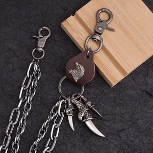 Details einer Punk-Hiphop-Hosenkette mit Adler-Lederpatch und Metallkrallen-Anhängern