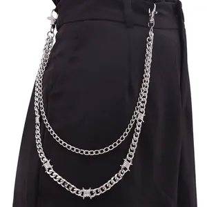 Detail of silver thorn Cuban chain on black pants featuring punk hip hop style hooks
