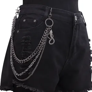 Detailansicht der dreilagigen Metall-Hosenkette mit Schlangenanhänger an schwarzer Jeans