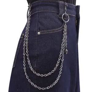 Detail of silver double-layered metal trousers chain with punk skull pendant on jeans