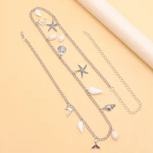 Detalle de cadena de cintura bohemia plateada con colgantes de conchas y estrellas de mar