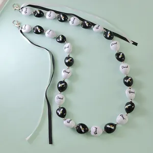 Détail de la chaîne de remise de diplôme en perles acryliques avec ruban noué
