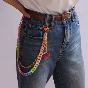 Detail der bunten Acryl-Hosenkette mit Regenbogen-Gliedern und Kirsch-Anhängern an Jeans