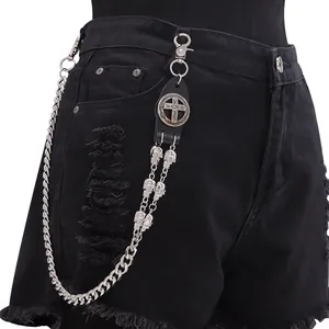 Makroansicht der silbernen Totenkopfkette und Kreuzmedaille an der Punk-Leder-Hosenkette