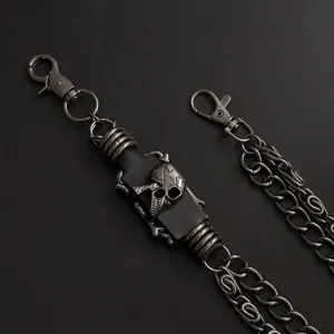 Detail of punk trousers chain featuring black leather patches and a silver metal skull
