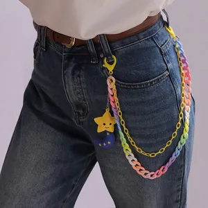 Detail der bunten Acryl-Hosenkette mit Stern- und Mondanhängern an einer Jeanshose