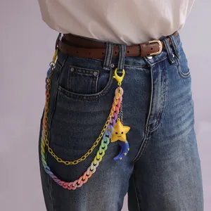 Detail einer bunten Acryl-Hosenkette mit Stern- und Mondanhängern auf Denim-Jeans