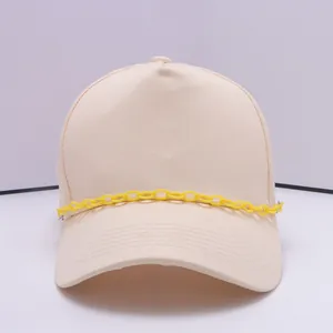 Detailansicht einer beigen Canvas-Baseballkappe mit einer dekorativen gelben Kunststoffkette