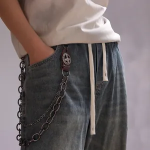 Close-up of double-layered punk pants chain with vintage leather and cross metal badge