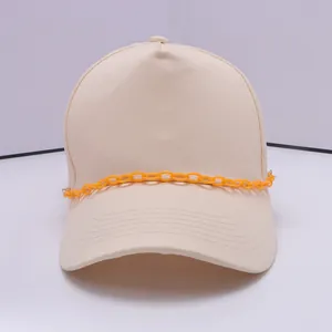 Detailansicht einer beigen Baseballkappe mit einer trendigen orangefarbenen Kunststoffkette