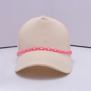Detailansicht der Baseballkappe mit trendigem rosa Kettenzubehör und Stoffstruktur