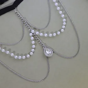 Détail d'une chaîne de cuisse multicouche avec perles blanches et cristal en forme de poire