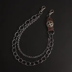 Detail of vintage leather cross accent and layered heavy metal biker wallet chains