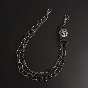 Close-up of double-layer punk chain with vintage leather cross pendant and lobster clasps