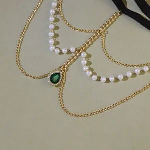 Détail de la chaîne de cuisse multicouche avec perles et pendentif goutte verte