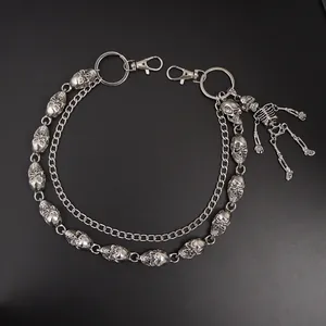 Detail einer silbernen Punk-Hosenkette mit Totenköpfen und beweglichem Skelett-Anhänger