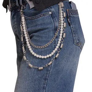 Detalle de cadena multicapa para pantalón con perlas sintéticas y eslabones metálicos