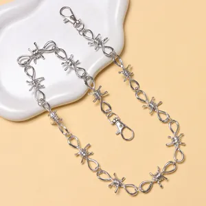 Dettaglio catena da vita argentata con design a spine e doppi moschettoni a scatto