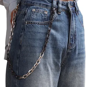 Detail of two-tone hip-hop waist chain with silver and black links on blue jeans