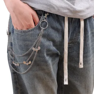 Detail of silver multi-layer metal trousers chain with wing charm on blue jeans