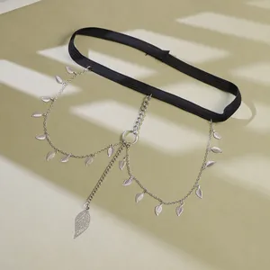 Detail of black elastic leg chain featuring silver leaf charms and metal ring accents