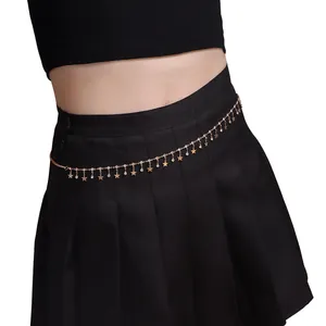 Detail of golden waist chain featuring dangling metal stars and sparkling rhinestones