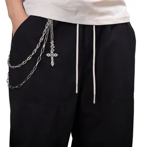 Dettaglio della catena per pantaloni multistrato in metallo con croce incisa