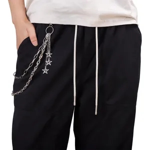 Dettaglio della catena hip-hop d'argento con ciondoli a stella su pantaloni neri