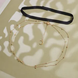 Detail of bohemian leg chain with sun and moon pendants on gold layered chains