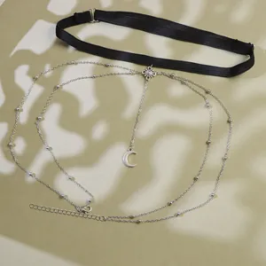 Detailed macro of a boho leg chain featuring a sun medallion and crescent moon charm