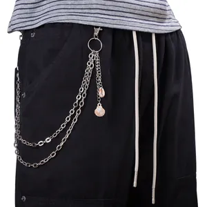 Détail de la chaîne de pantalon multicouche en métal argenté avec pendentifs coquillages