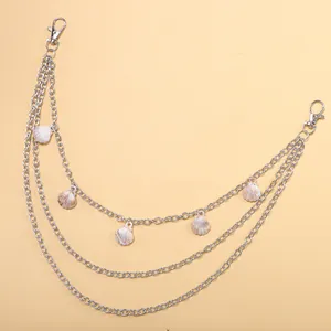 Détail d'une chaîne de pantalon en métal argenté à 3 couches avec pendentifs coquillages