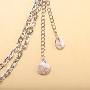 Vue détaillée de chaînes argentées multicouches avec pendentifs coquillages sur fond plat